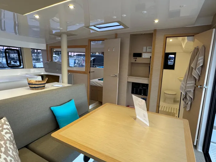 Stock Neel 47 Yacht Photos Pics Interior of 2023 NEEL 47 trimaran with modern dining area and cozy cabin.