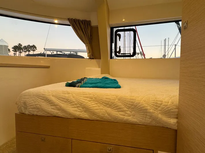 Stock Neel 47 Yacht Photos Pics Cozy cabin interior of 2023 NEEL 47 trimaran with bed and window view.