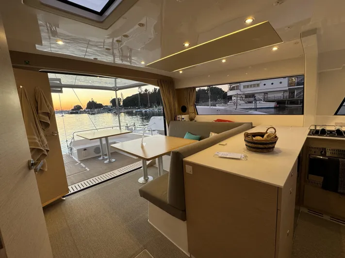 Stock Neel 47 Yacht Photos Pics Interior of 2023 NEEL 47 yacht with sunset view, modern seating, and kitchen area.