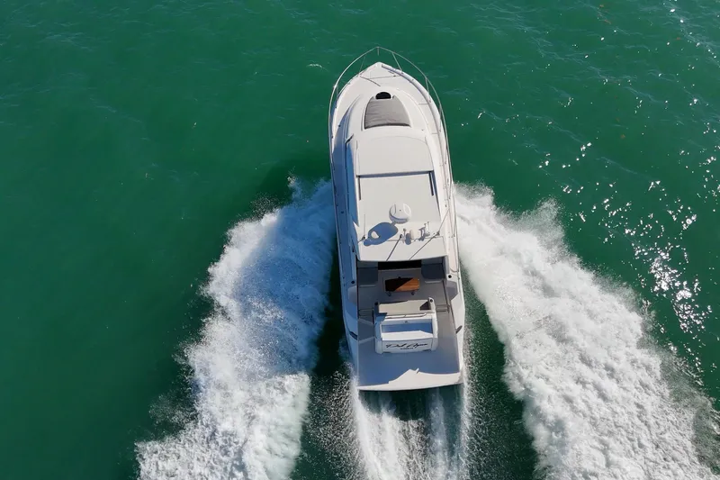 Pal Agua Yacht Photos Pics 2023 Tiara Yachts C39 Coupe cruising on turquoise water, aerial view.