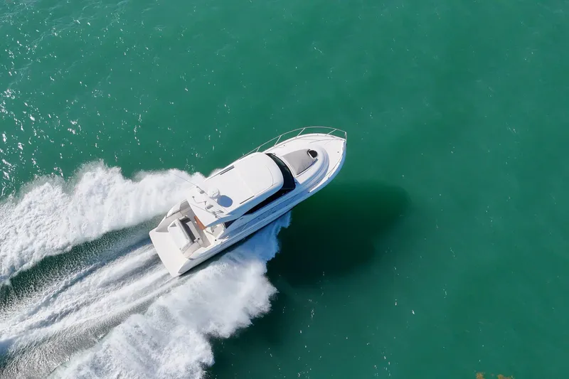 Pal Agua Yacht Photos Pics 2023 Tiara Yachts C39 Coupe cruising on turquoise water, aerial view.