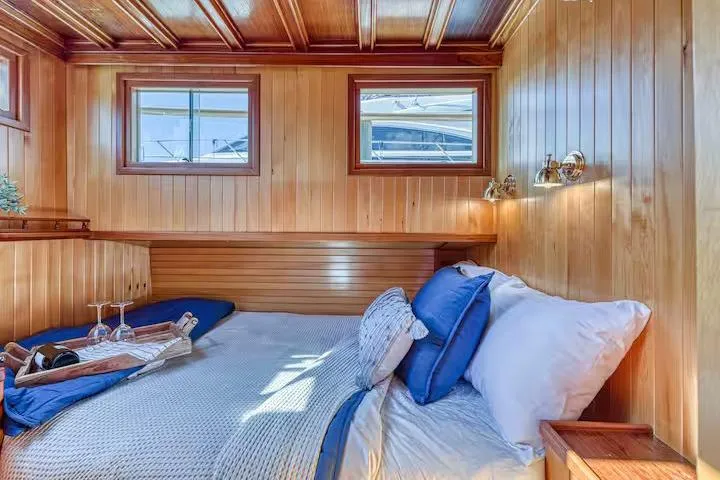  Yacht Photos Pics Cozy wooden cabin interior on 1981 Nielsen 46 yacht with bed and nautical decor.