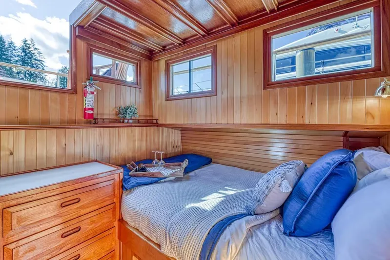  Yacht Photos Pics Cozy wooden cabin interior on 1981 Nielsen 46 boat, featuring a comfortable bed and natural light.