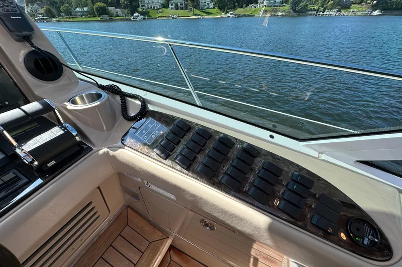 Knot Rite Yacht Photos Pics Control panel of a 2009 Sea Ray 60 Sundancer yacht overlooking a serene lake.