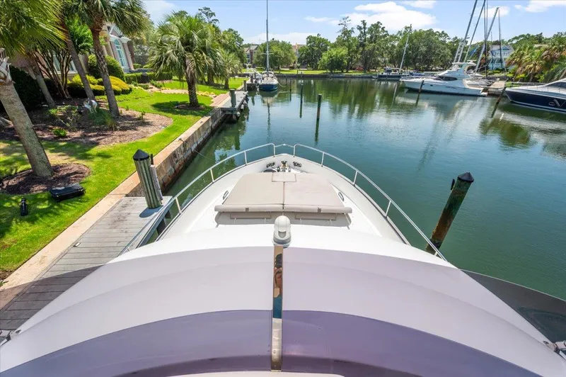 Tangerine Moon Yacht Photos Pics Azimut Magellano 43 yacht docked in a serene marina, surrounded by lush greenery.