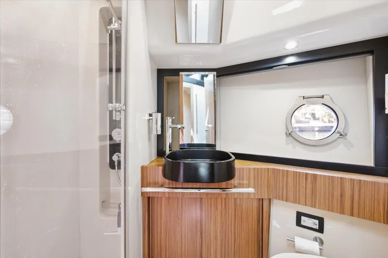 Tangerine Moon Yacht Photos Pics Luxurious bathroom interior of 2014 Azimut Magellano 43 yacht with modern fixtures and porthole window.