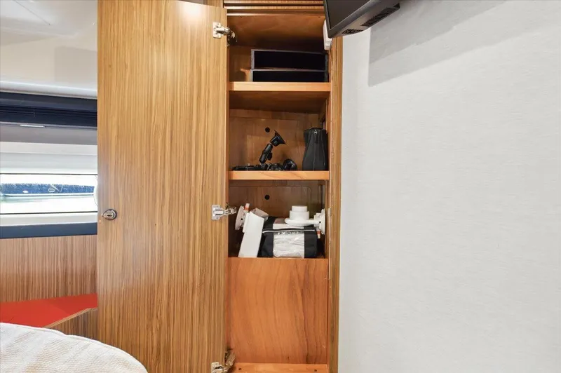 Tangerine Moon Yacht Photos Pics Open wooden cabinet with shelves inside Azimut Magellano 43 yacht, 2014 model.