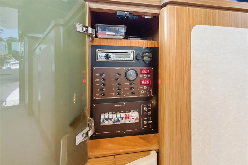 Tangerine Moon Yacht Photos Pics Electrical control panel inside 2014 Azimut Magellano 43 yacht, featuring switches and digital displays.