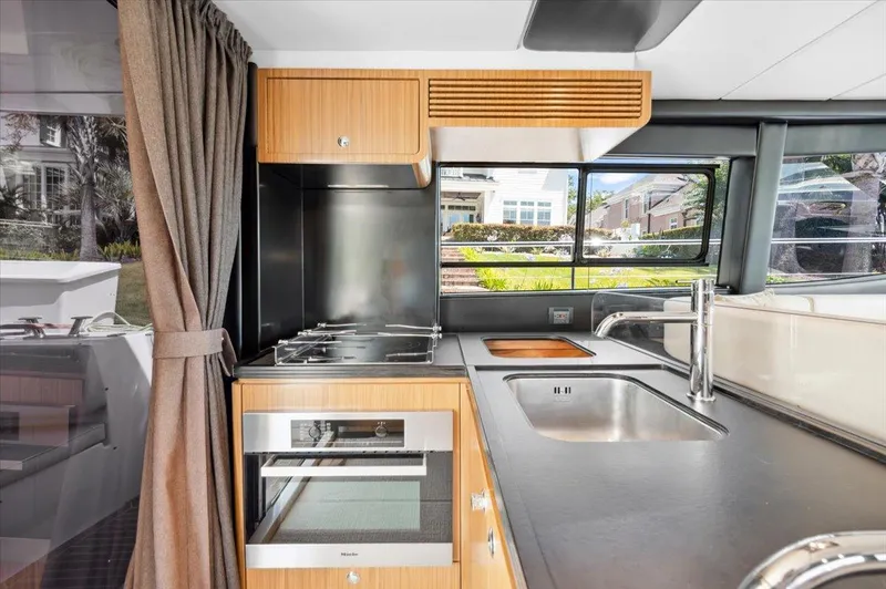 Tangerine Moon Yacht Photos Pics Modern kitchen interior on 2014 Azimut Magellano 43 yacht, featuring sleek appliances and large windows.