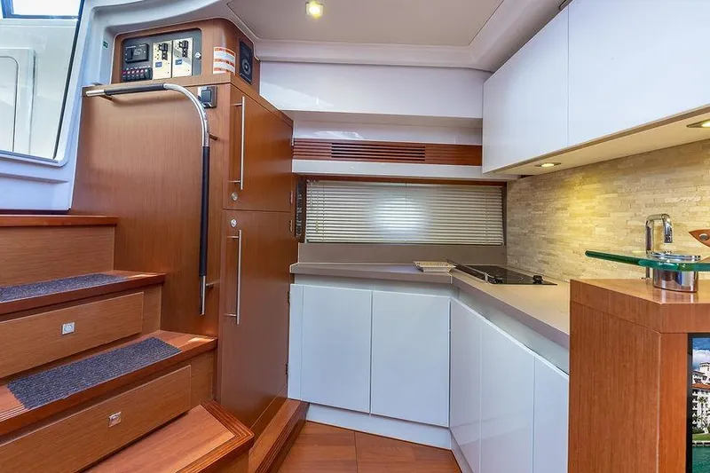 Alegria Yacht Photos Pics Interior of 2015 Beneteau Gran Turismo 44 yacht, featuring modern kitchen and wooden stairs.