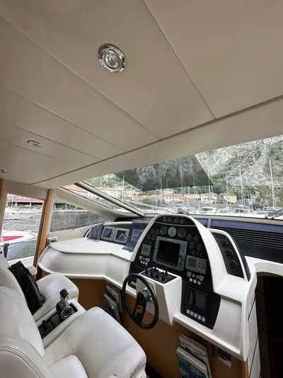 Yacht Photos Pics Interior view of 2005 Pershing 76 yacht cockpit with modern controls and leather seating.