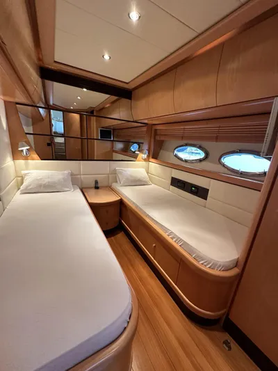  Yacht Photos Pics Luxurious twin cabin interior of 2005 Pershing 76 yacht with wooden finishes and porthole windows.