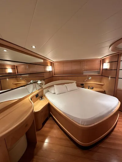  Yacht Photos Pics Luxurious cabin interior of 2005 Pershing 76 yacht with elegant wood finishes and cozy bed.