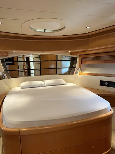  Yacht Photos Pics Luxurious bedroom interior of 2005 Pershing 76 yacht with elegant wood finishes.