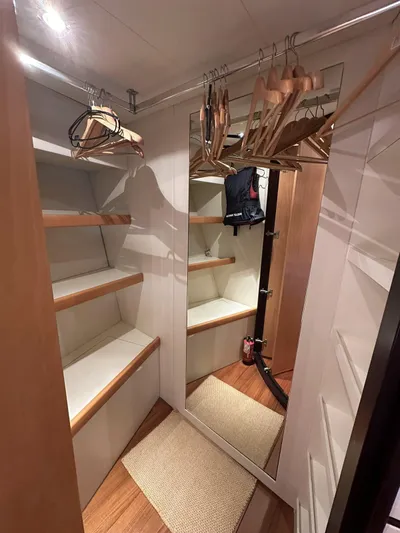  Yacht Photos Pics Walk-in closet with wooden shelves and hangers on a 2005 Pershing 76 yacht.