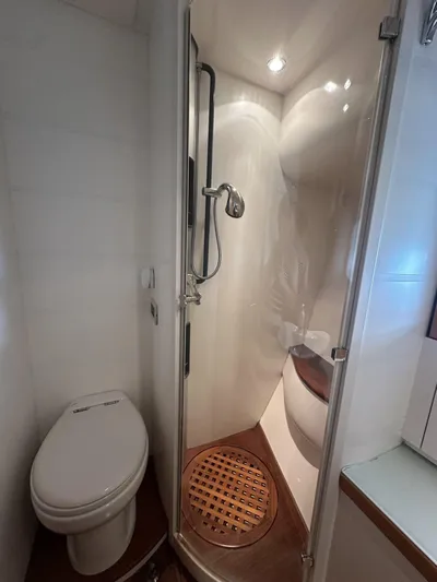  Yacht Photos Pics Bathroom interior of a 2005 Pershing 76 yacht, featuring a compact shower and toilet.