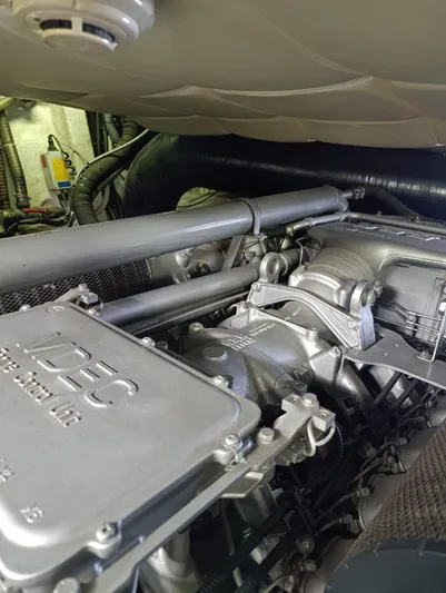  Yacht Photos Pics Engine compartment of a 2005 Pershing 76 yacht, showcasing mechanical components and piping.