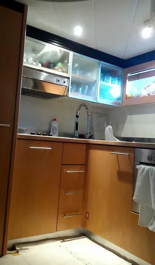  Yacht Photos Pics Modern kitchen interior of 2005 Pershing 76 yacht with wood cabinets and stainless steel appliances.