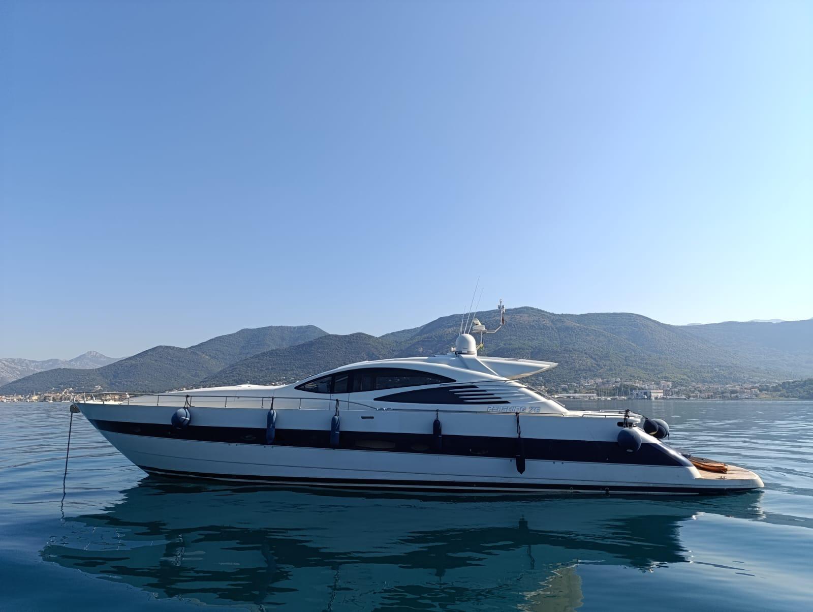 2005 Pershing 76 yacht on calm water with mountainous backdrop.