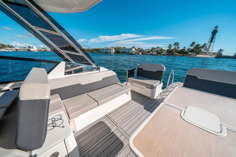 Era Ora Yacht Photos Pics Aquila 32 Sport 2022 boat interior with ocean view and lighthouse in background.
