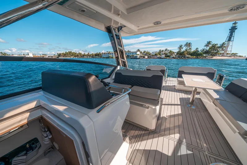 Era Ora Yacht Photos Pics 2022 Aquila 32 Sport yacht interior with ocean view and lighthouse in background.