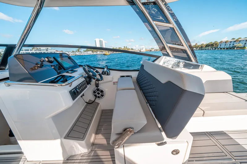 Era Ora Yacht Photos Pics Aquila 32 Sport 2022 boat interior with modern helm and seating, on a sunny day.