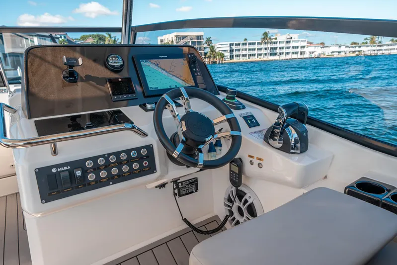 Era Ora Yacht Photos Pics Helm of 2022 Aquila 32 Sport boat with navigation controls and ocean view.