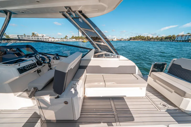 Era Ora Yacht Photos Pics 2022 Aquila 32 Sport yacht interior with seating, steering, and ocean view.
