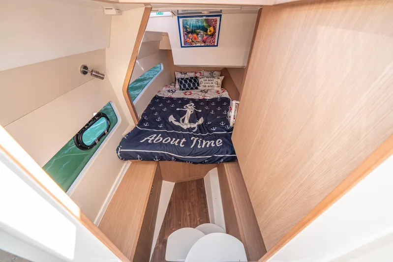 Era Ora Yacht Photos Pics Cozy cabin interior of 2022 Aquila 32 Sport with nautical-themed bedding.