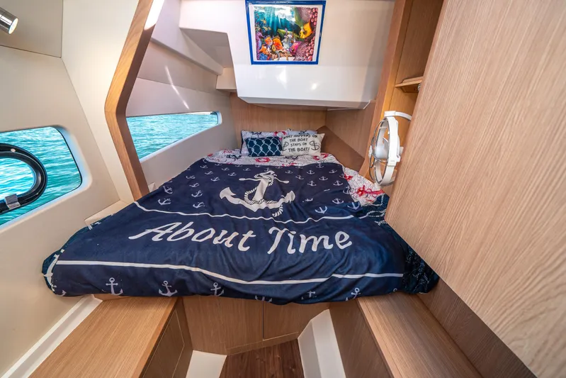 Era Ora Yacht Photos Pics Cozy cabin interior of 2022 Aquila 32 Sport with nautical-themed bedding.