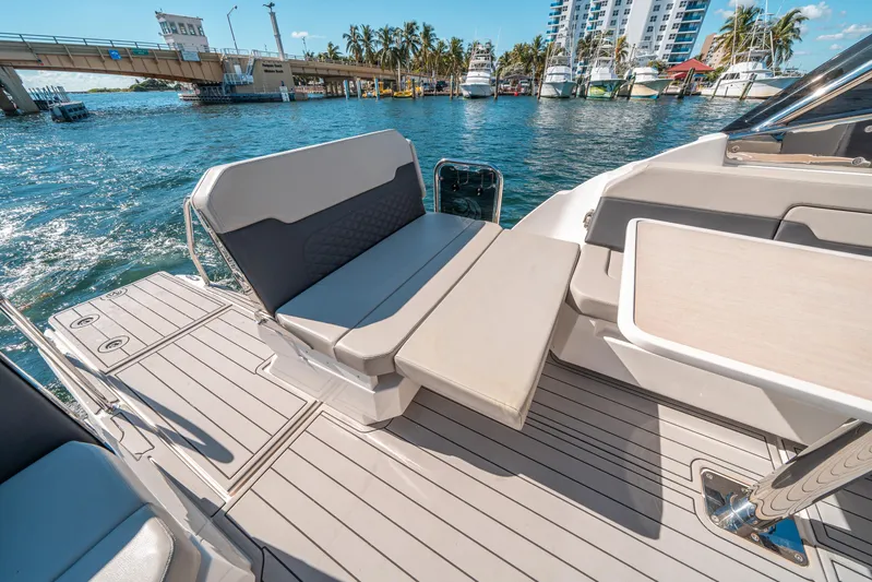 Era Ora Yacht Photos Pics Aquila 32 Sport 2022 boat interior with seating and table, docked near a bridge.