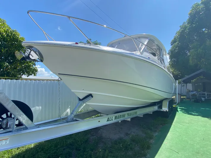  Yacht Photos Pics 2007 Boston Whaler 320 Outrage Cuddy Cabin on trailer, sunny day, green grass.
