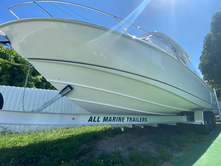  Yacht Photos Pics 2007 Boston Whaler 320 Outrage Cuddy Cabin on trailer, sunny day, side view.