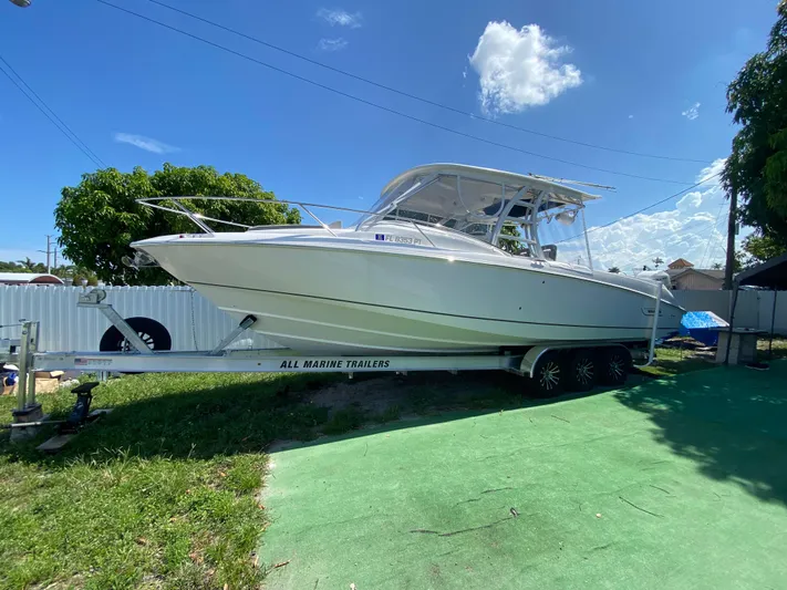  Yacht Photos Pics 2007 Boston Whaler 320 Outrage Cuddy Cabin on trailer, sunny day, green grass.