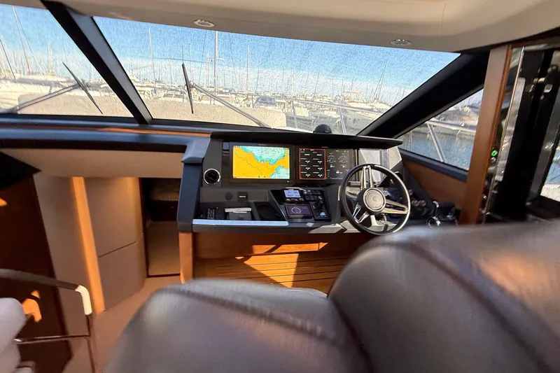 Stra Dodo Yacht Photos Pics Interior view of 2019 Princess S65 yacht cockpit with navigation screens and steering wheel.