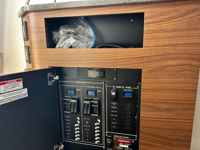  Yacht Photos Pics 2021 Boston Whaler 350 EX electrical panel in wooden cabinet.