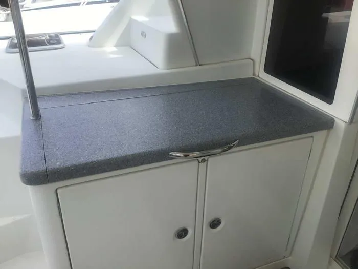 Katarina Yacht Photos Pics Interior view of a 2010 Lagoon 440 yacht with a sleek countertop and storage cabinets.