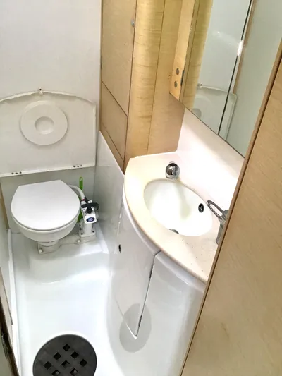 Katarina Yacht Photos Pics 2010 Lagoon 440 yacht bathroom with toilet, sink, and wooden cabinetry.