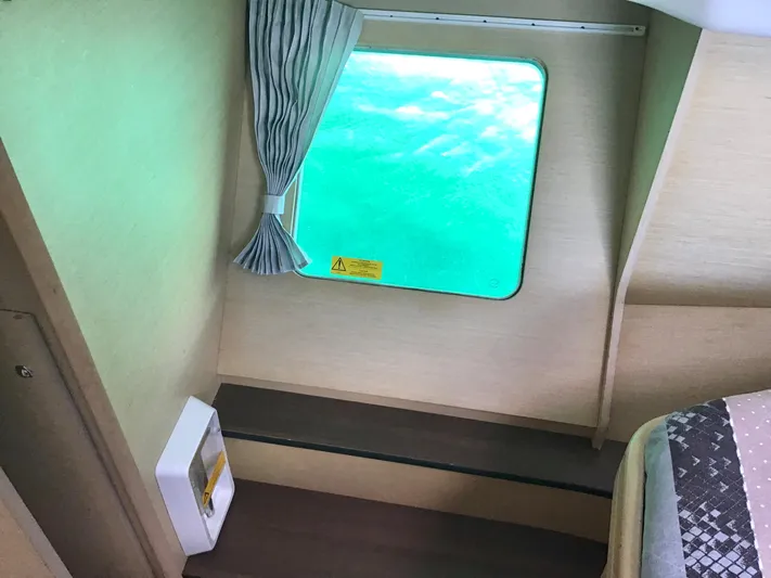 Katarina Yacht Photos Pics Interior of 2010 Lagoon 440 yacht cabin with window view of turquoise water.