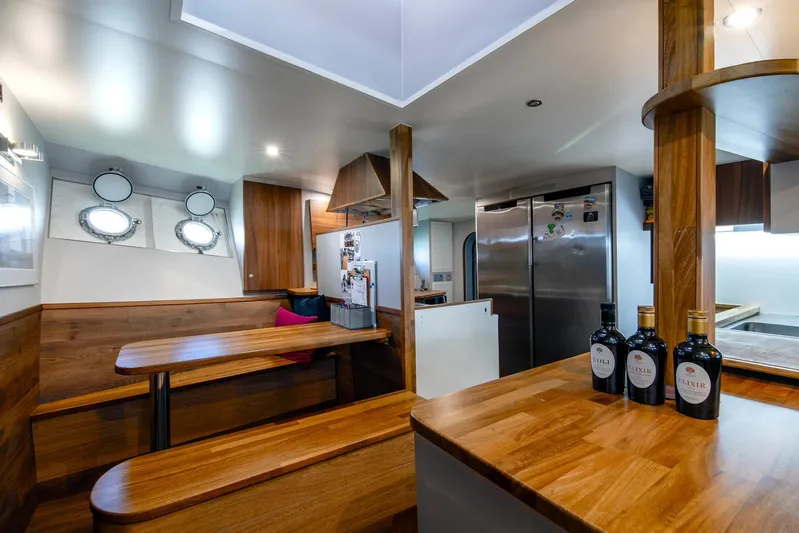 La Fenice Yacht Photos Pics Interior of 1962 Laurent Giles TSDMY yacht with wooden dining area and modern kitchen.