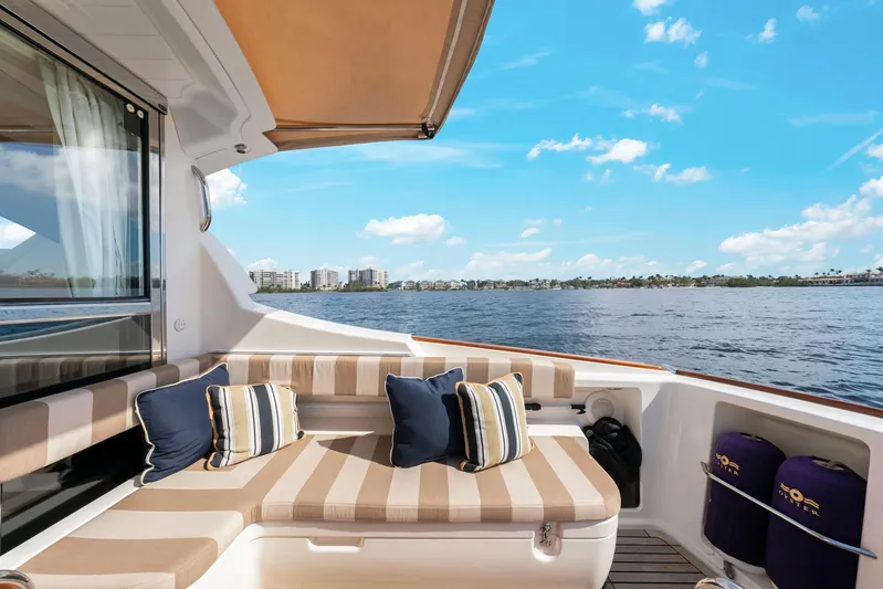 Lady Di Yacht Photos Pics Luxurious 2007 Oyster LD43 yacht deck with striped seating, cushions, and scenic waterfront view.