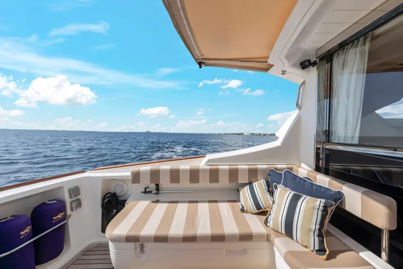 Lady Di Yacht Photos Pics 2007 Oyster LD43 yacht deck with striped seating, ocean view, and blue sky.