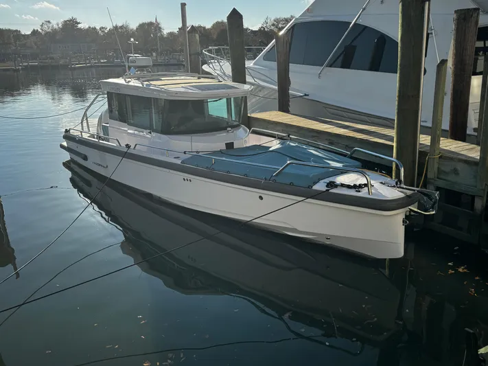 Lemaire Yacht Photos Pics 2023 Axopar 28 CABIN boat docked in a serene marina setting.