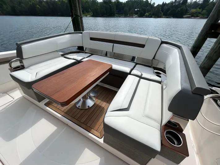  Yacht Photos Pics Luxurious seating area on 2019 Tiara Yachts 38 LS, featuring elegant wood table and lake view.
