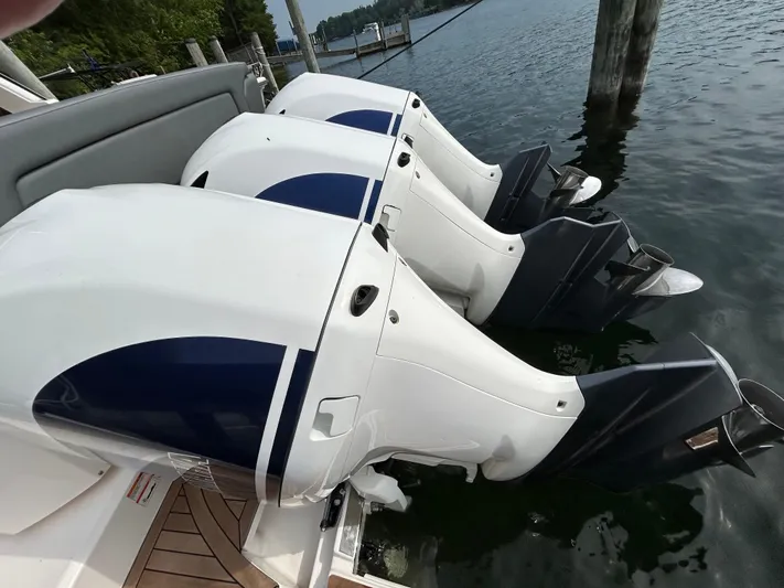  Yacht Photos Pics 2019 Tiara Yachts 38 LS with triple outboard engines docked on calm water.