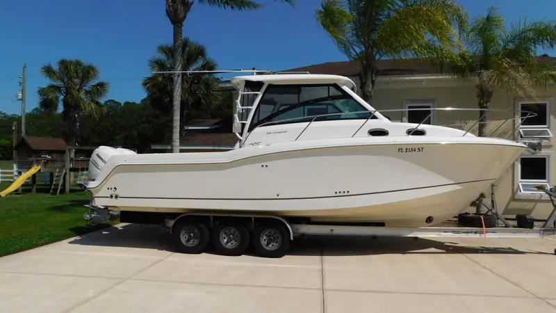  Yacht Photos Pics 2017 Boston Whaler 315 Conquest boat on trailer, parked in driveway with palm trees.