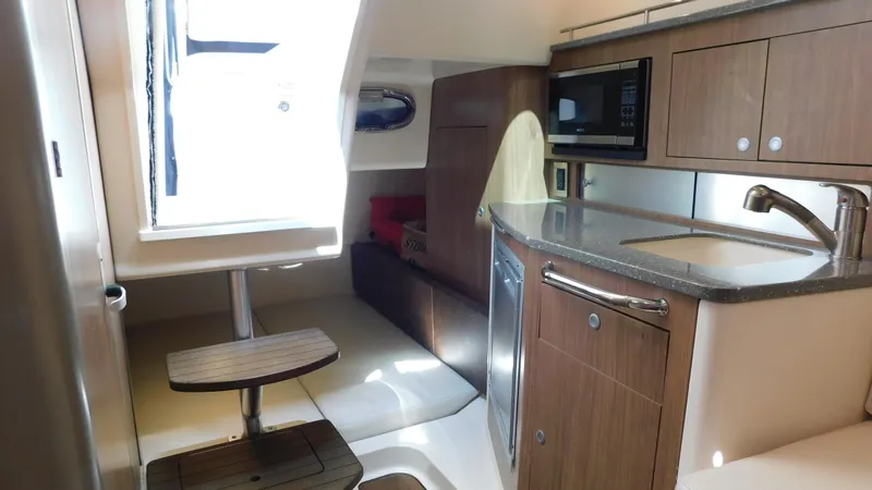  Yacht Photos Pics Interior of 2017 Boston Whaler 315 Conquest boat with kitchenette and seating area.
