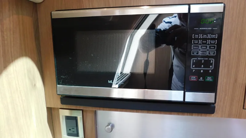  Yacht Photos Pics Microwave inside 2017 Boston Whaler 315 Conquest boat cabin, featuring wood paneling.