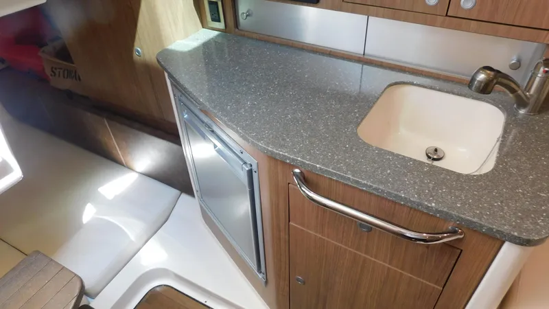  Yacht Photos Pics 2017 Boston Whaler 315 Conquest interior with kitchenette, featuring sink and countertop.