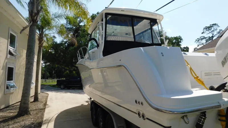  Yacht Photos Pics 2017 Boston Whaler 315 Conquest boat parked outdoors, surrounded by trees and buildings.